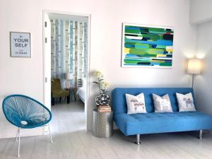 a living room with a blue couch and a chair at By The Sea Suite,Batu Ferringhi in Batu Ferringhi