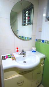 a bathroom with a sink and a mirror at Premium Family Deluxe Apartment in Bāiljuri