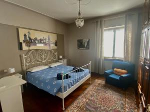 a bedroom with a bed and a blue chair at Villa Germana in Castenedolo