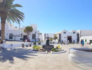 einen Platz mit einem Brunnen, Palmen und Gebäuden in der Unterkunft Apartamento tranquilo en la Villa de Teguise Lanzarote in Teguise