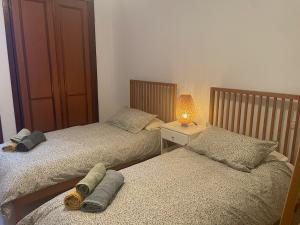 2 Betten in einem Schlafzimmer mit einer Lampe auf einem Tisch in der Unterkunft Apartamento tranquilo en la Villa de Teguise Lanzarote in Teguise