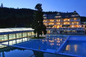 a hotel with a pool in front of a building at Apartmán Tymián in Vyšné Ružbachy