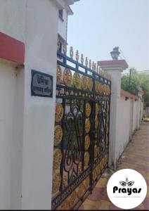 a gate of a building with a sign on it at Udita Homestay Prayas in Shānti Niketan