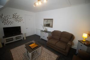 a living room with a couch and a television at Beautify Refurbished Large 3 Bed Terrace in Hawick