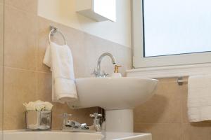 a bathroom with a sink and a toilet and a window at Beautify Refurbished Large 3 Bed Terrace in Hawick