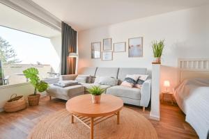 un soggiorno con letto, divano e tavolo di Ferienwohnung Hygge Sol Mare Whg 52 mit Schwimmbad Innenpool und Sauna Kellenhusen a Kellenhusen