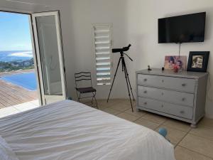 Televiisor ja/või meelelahutuskeskus majutusasutuses Villa Sunset avec piscine miroir et vue panoramique