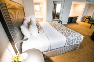 a hotel room with a large bed with white sheets and pillows at Crowne Plaza Managua, an IHG Hotel in Managua