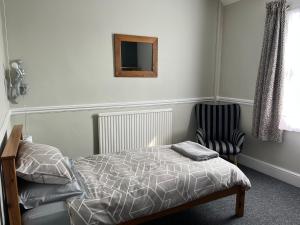 a bedroom with a bed and a chair at Bourton House in Rugby +8 photos