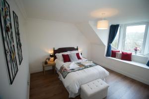 a white bedroom with two beds and a window at Spacious 3 Bed Terrace with Large Kitchen Diner in Hawick