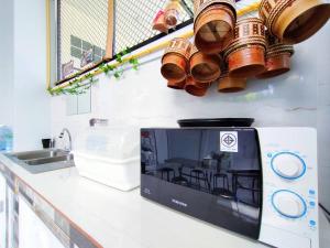 a kitchen counter with a microwave and a sink at Nana hostel in Nakhon Phanom