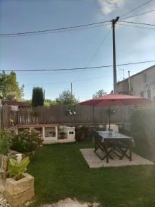 a backyard with a table and an umbrella at La Casina di Nonna Altea in Massa