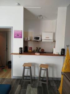 a kitchen with two stools next to a counter at Appartement dans charmante petite résidence in Bergerac