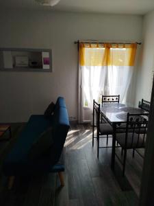 a living room with a table and chairs and a window at Appartement dans charmante petite résidence in Bergerac