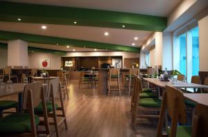 a restaurant with tables and chairs and green walls at Nest By TreeHouse Bhiwadi in Bhiwadi