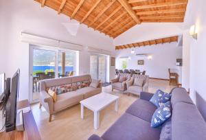 a living room with a couch and a tv at Villa Nane in Kaş