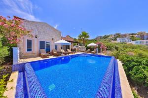a swimming pool in front of a house at Villa Nane in Kaş