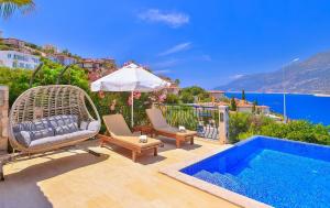 a villa with a swimming pool with chairs and a swing at Villa Nane in Kaş