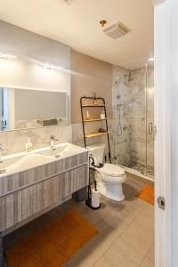 a bathroom with a tub and a toilet and a sink at Stylish SOHO-Inspired Loft, 15 Min to NYC Times Square in Union City
