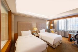 Postel nebo postele na pokoji v ubytování Sofitel Harbin