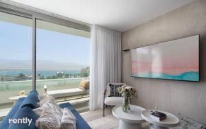 埃拉特Luxury Apartments And Studios At Sea Side By Rently的客厅设有蓝色的沙发和大窗户
