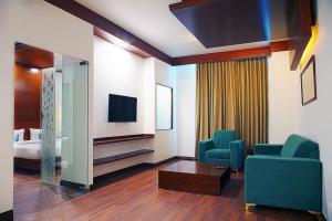 a room with two chairs and a tv and a bed at Nest By TreeHouse Bhiwadi in Bhiwadi