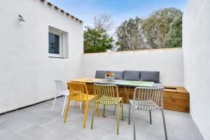 eine Terrasse mit einem Tisch und 4 Stühlen in der Unterkunft Jolie maison pour 8 - 400m de la plage - terrasse in La Guérinière