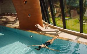 a man is swimming in a swimming pool at Grand Hotel Kronenhof in Pontresina