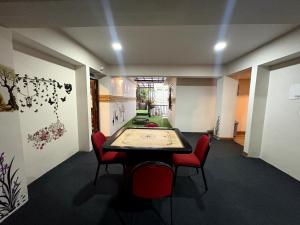 a room with a ping pong table and red chairs at Hotel Tempo Heritage Resort In Gangtok in Gangtok