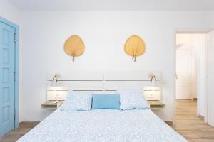 ein weißes Schlafzimmer mit einem großen Bett mit blauen Kissen in der Unterkunft Home2Book Stunning Views Bungalow Costa Adeje in Adeje + 46 Fotos