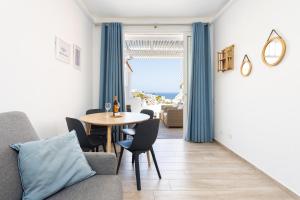 ein Wohnzimmer mit Tisch und Stühlen und einem Fenster in der Unterkunft Home2Book Stunning Views Bungalow Costa Adeje in Adeje