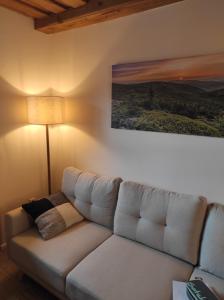 un canapé blanc dans un salon avec un tableau dans l'établissement "BayernWald 201" Ferienwohnung mit Pool und Sauna, à Hauzenberg