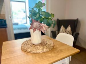 a vase with a plant in it sitting on a table at A city oasis - full apartment with balcony in Perth