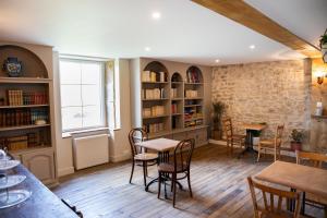 a dining room with tables and chairs and a brick wall at La Comtoiserie in Nancray