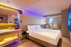 乌鲁木齐Ruby Elegant Hotel Xinjiang Uygur Autonomous Region Museum Branch的酒店客房设有一张大床和一间浴室。