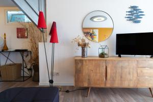 a living room with a tv on a dresser with a mirror at Grand T2 ensoleillé in La Grande-Motte