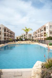 Una gran piscina frente a unos edificios de apartamentos. en Royal Seacrest F G5 ground floor apartment, en Pafos