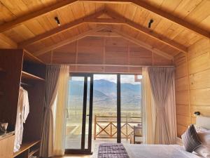 a bedroom with a bed and a large window at Gangtey Pinewood Resort in Gangtey Gonpa +6 photos