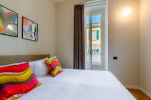 a bedroom with a large white bed with colorful pillows at R Oleandro House in Como