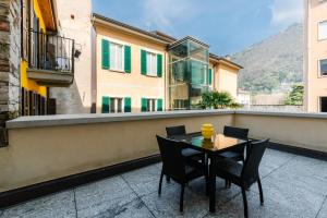 a patio with a table and chairs on a balcony at R Oleandro House in Como