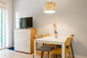 a dining room with a white table and chairs at Apartments Kržanić in Podgora