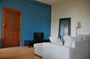 un soggiorno con divano bianco e parete blu di agréable duplex Candé centre ville 4/6 places a Candé