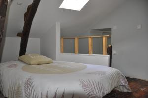 un letto bianco in una stanza con una finestra di agréable duplex Candé centre ville 4/6 places a Candé