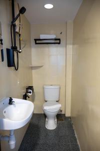 a bathroom with a white toilet and a sink at Orkid Inn Kajang in Kajang +21 photos