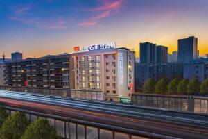 乌鲁木齐Ruby Elegant Hotel Xinjiang Uygur Autonomous Region Museum Branch的高速公路上的一栋建筑，背景是一座城市