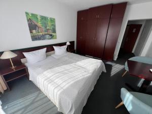 a bedroom with a large bed with a white comforter at Pension am Markt in Lübben