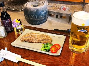 a table with a plate of food and a glass of beer at Yuuzuru in Ito