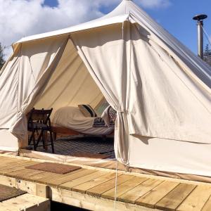 PenuwchTinker the Bell Tent at Pentref Luxury Camping的白色帐篷,有人睡在帐篷里 更多14张照片