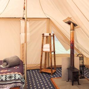 PenuwchTinker the Bell Tent at Pentref Luxury Camping的一间带梯子和椅子的帐篷的房间