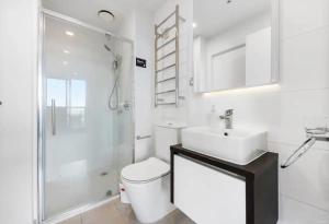 a bathroom with a toilet and a sink and a shower at Gorgeous Seaview and Harbour View 2 BDR 2 BTH Apartment in Auckland